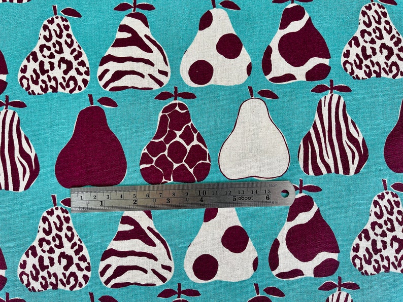 May include: A turquoise fabric with a repeating pattern of pears. The pears are in various shades of brown and white and have different patterns, including leopard print, zebra stripes, and polka dots.