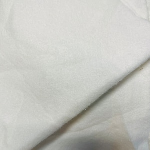May include: White fleece fabric, soft and fluffy, with a smooth texture. The fabric is folded in half, showing the inside and outside of the material.