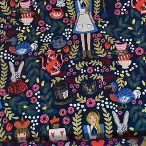 Pu&ograve; includere: Un tessuto blu scuro con un motivo ripetuto di personaggi di Alice nel Paese delle Meraviglie, tra cui Alice, il Cappellaio Matto, la Regina di Cuori e il Gatto del Cheshire. Il motivo include anche tazze da t&egrave;, rose e altri elementi fantasiosi.