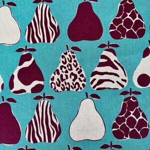 May include: A turquoise fabric with a repeating pattern of pears. The pears are in various shades of white, brown, and burgundy. Each pear has a different pattern, including zebra stripes, leopard spots, and polka dots. The fabric has the text "OSKIKKA - HOKKOH PRINTED IN JAPAN" in the bottom left corner.