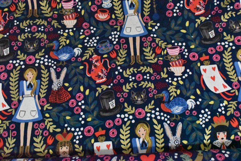 Pu&ograve; includere: Un tessuto blu scuro con un motivo ripetuto di personaggi di Alice nel Paese delle Meraviglie, tra cui Alice, il Cappellaio Matto, la Regina di Cuori e il Gatto del Cheshire. Il motivo include anche tazze da t&egrave;, rose e altri elementi fantasiosi.