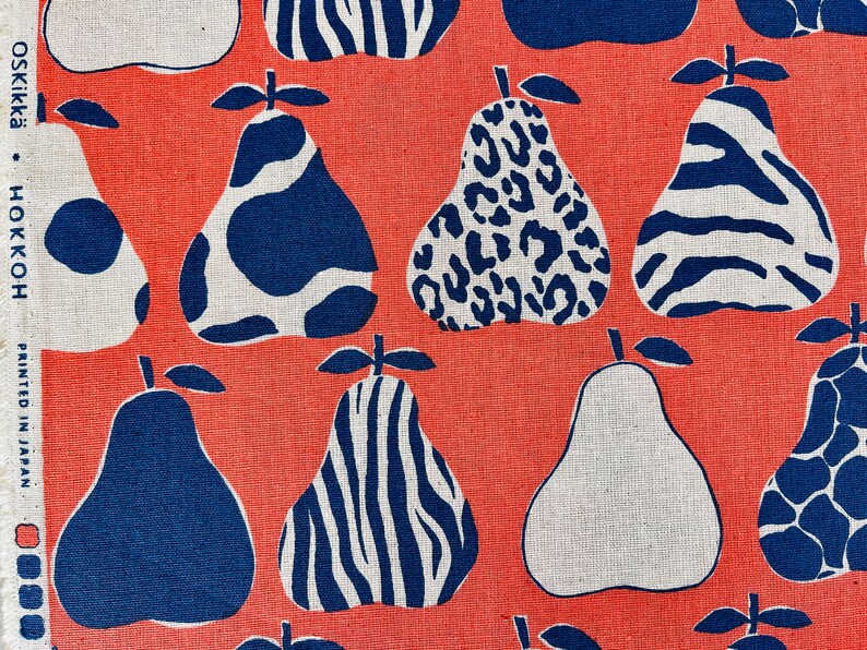 May include: A coral red fabric with a repeating pattern of blue and white pears. The pears have different patterns, including zebra stripes, leopard spots, and cow spots.