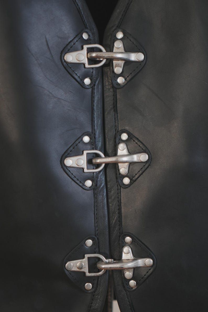 Close-up of side buckle and riveted leather panel on motorcycle vest