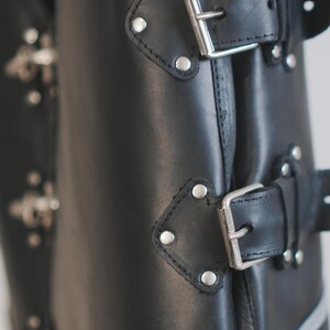 Close-up of front clasp hardware on black leather motorcycle vest