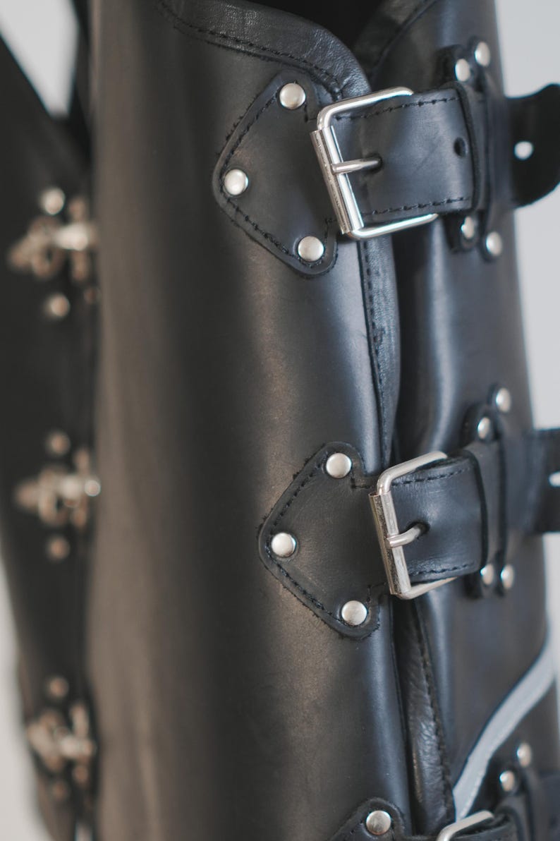 Close-up of front clasp hardware on black leather motorcycle vest