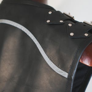 Shoulder buckle detail on handmade black leather biker vest