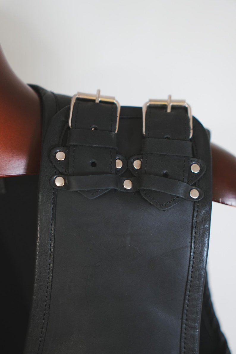 Shoulder buckle detail on handmade black leather biker vest