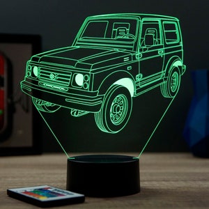 Op de afbeelding: Een neon groene LED-lamp in de vorm van een klassieke terreinwagen. De lamp heeft een gedetailleerde omtrek van de carrosserie, wielen en ramen van het voertuig, gemonteerd op een zwarte basis. Een afstandsbediening is zichtbaar op de voorgrond.