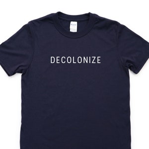 May include: A navy blue t-shirt with the text "DECOLONIZE" printed in white on the front.