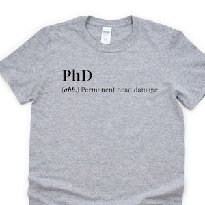 May include: Gray t-shirt with black text that reads "PhD (abb.) Permanent head damage."