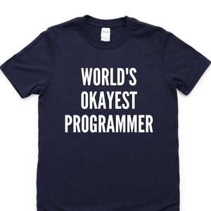 May include: A navy blue t-shirt with white text that reads "WORLD'S OKAYEST PROGRAMMER".