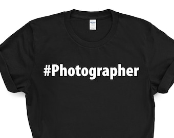 May include: Black t-shirt with white text that reads "#Photographer".