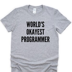 May include: A gray t-shirt with black text that reads "WORLD'S OKAYEST PROGRAMMER".