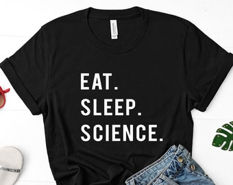 Op de afbeelding: Zwart T-shirt met witte tekst die "Eat. Sleep. Science." luidt.