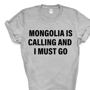 Może przedstawiać: Szary T-shirt z czarnym napisem "Mongolia wzywa i muszę iść."