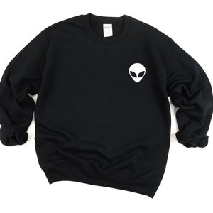 May include: Black sweatshirt with a white alien face graphic on the front.
