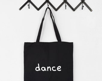 May include: Black canvas tote bag with white text that says "dance".