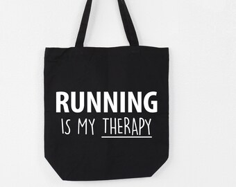 Puede incluir: Bolsa de tela negra con texto blanco que dice "RUNNING IS MY THERAPY".