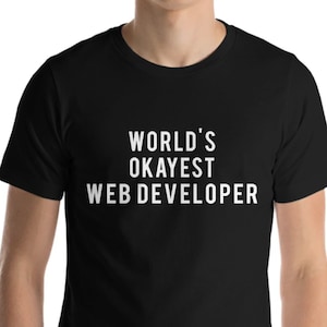 Può includere: Maglietta nera con testo bianco che dice "WORLD'S OKAYEST WEB DEVELOPER"