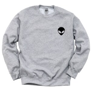 May include: A gray sweatshirt with a black alien face graphic on the front.