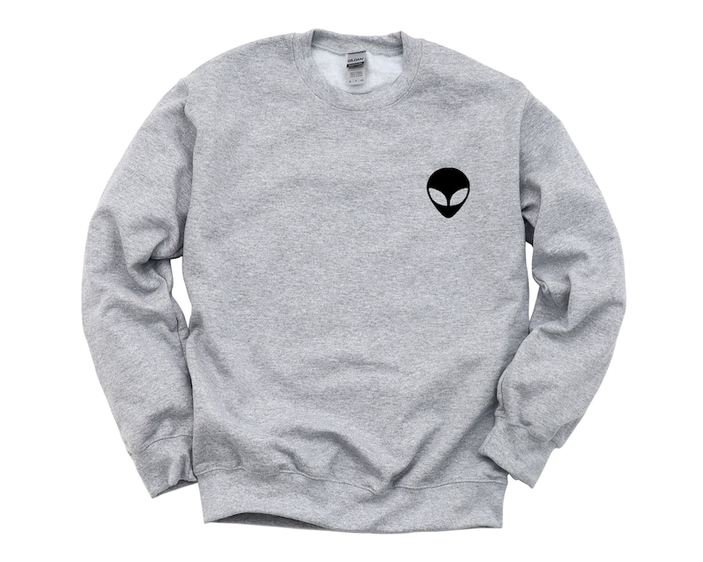 May include: A gray sweatshirt with a black alien face graphic on the front.
