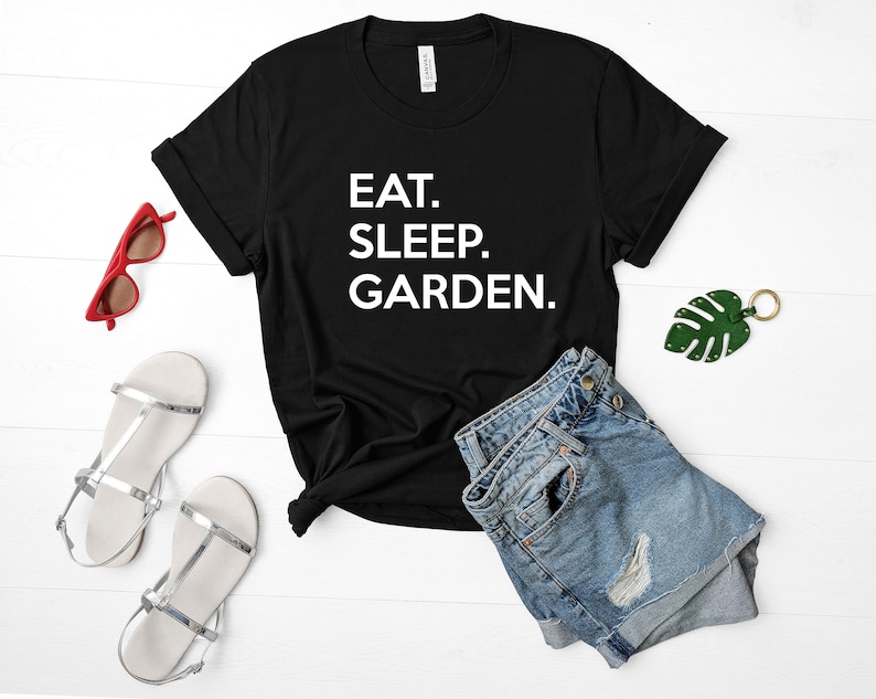 May include: Black t-shirt with white text that reads "EAT. SLEEP. GARDEN."
