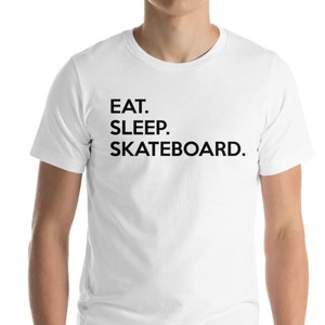 K&ouml;nnte beinhalten: Wei&szlig;es T-Shirt mit schwarzem Text, der "EAT. SLEEP. SKATEBOARD." lautet.