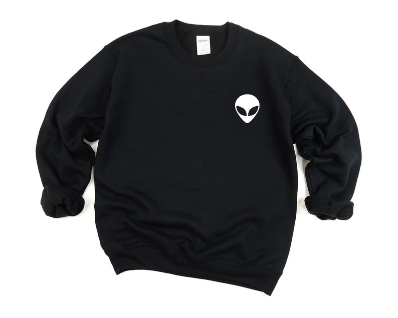 May include: Black sweatshirt with a white alien face graphic on the front.