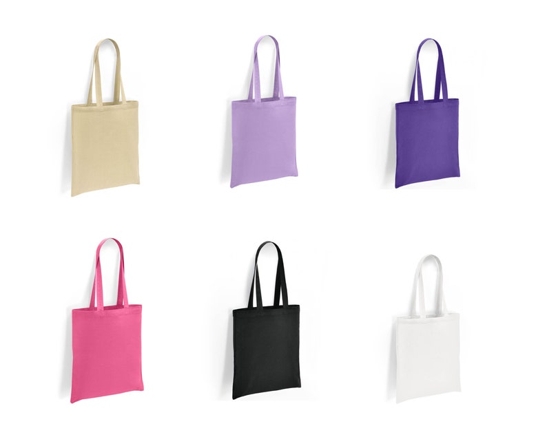 May include: Six tote bags in different colours: beige, lavender, purple, pink, black, and white. The bags are made of canvas and have a simple design.