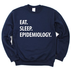 K&ouml;nnte beinhalten: Marineblauer Sweatshirt mit wei&szlig;em Text, der "Essen. Schlafen. Epidemiologie." lautet.