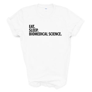 Puede incluir: Camiseta blanca con texto negro que dice "Comer. Dormir. Ciencia biom&eacute;dica."
