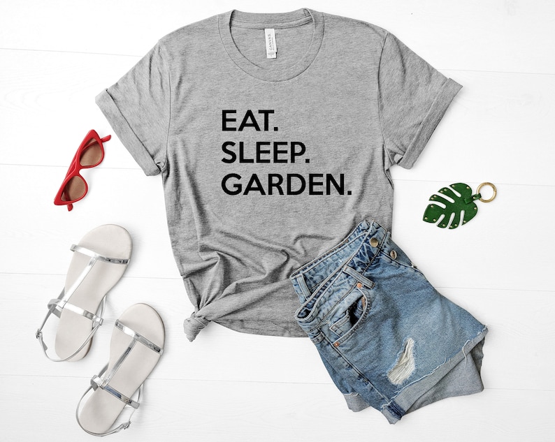 May include: A gray t-shirt with the text "EAT. SLEEP. GARDEN." printed in black.