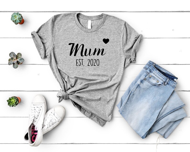 May include: Gray t-shirt with the text "Mum Est. 2020" and a small black heart.
