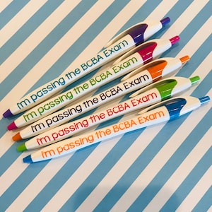 May include: Five white pens with colorful ink and the text "I'm passing the BCBA Exam" printed on them.