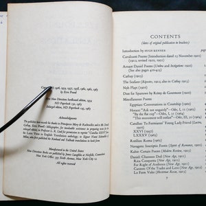 May include: A book titled "The Cantos" by Ezra Pound. The book cover is white with black text. The contents page lists the poems included in the book, with page numbers and dates of original publication.