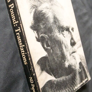 May include: A black and white photo of Ezra Pound on the cover of a book titled "Ezra Pound: Translations" with the subtitle "ND Paperbook 145".