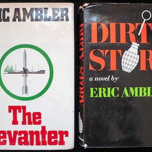 Puede incluir: Dos libros antiguos de Eric Ambler. "The Levater" tiene una portada blanca con un diseño de círculo verde y texto rojo. "Dirty Story" tiene una portada negra con texto naranja y una ilustración de granada.