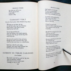 May include: A page from a book of French poetry by Jean Arthur Rimbaud. The page features two poems, "Cabaret Vert" and "Comedy in Three Caresses". The text is printed in black ink on white paper.