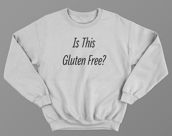 May include: A light gray sweatshirt with the text "Is This Gluten Free?" in black script. The sweatshirt has a crew neck and long sleeves. The garment is displayed on a gray background.