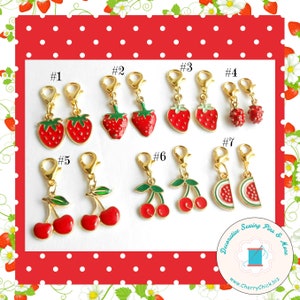 May include: Seven pairs of decorative sewing pins with fruit charms. The charms include strawberries, cherries, and watermelon slices. The pins are gold-toned and have a spring-loaded clasp.