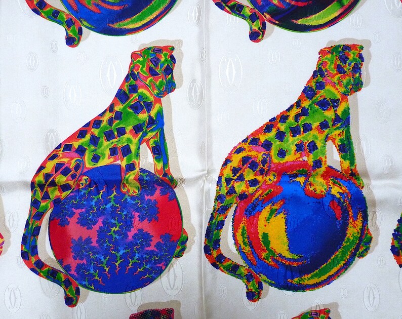 May include: Two colorful leopards are sitting on top of spheres. The leopards are green, yellow, blue, and red. The spheres are blue, yellow, red, and green. The background is white with a repeating pattern.