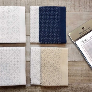 May include: Four white and blue fabric squares with geometric patterns, and a package of "Sashiko" embroidery kits. The kits include a pre-printed fabric square with a circle in the center and instructions for embroidery.