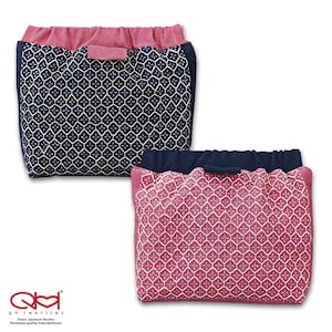 Peut inclure: Deux pochettes en tissu avec une fermeture à cordon. La pochette de gauche est bleu marine avec un motif géométrique blanc. La pochette de droite est rose avec un motif géométrique blanc.