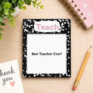 May include: A rectangular picture frame with a black and white speckled composition notebook pattern. The top border features the word Teach in pink lettering. The center white area displays the black printed text Best Teacher Ever!