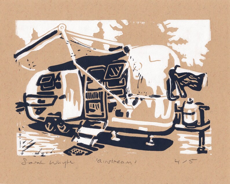 May include: A black and white linocut print of a camper van with a pop-up awning. The print is titled "Airstream" and is numbered 4/5. The artist's name, Sarah Whyte, is signed in the bottom left corner.