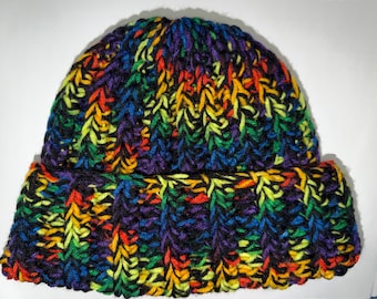 May include: A handmade, colorful beanie hat. The hat is knitted with a variety of vibrant colors, including red, orange, yellow, green, blue, and purple. The hat has a folded brim and a ribbed texture, perfect for cold weather.