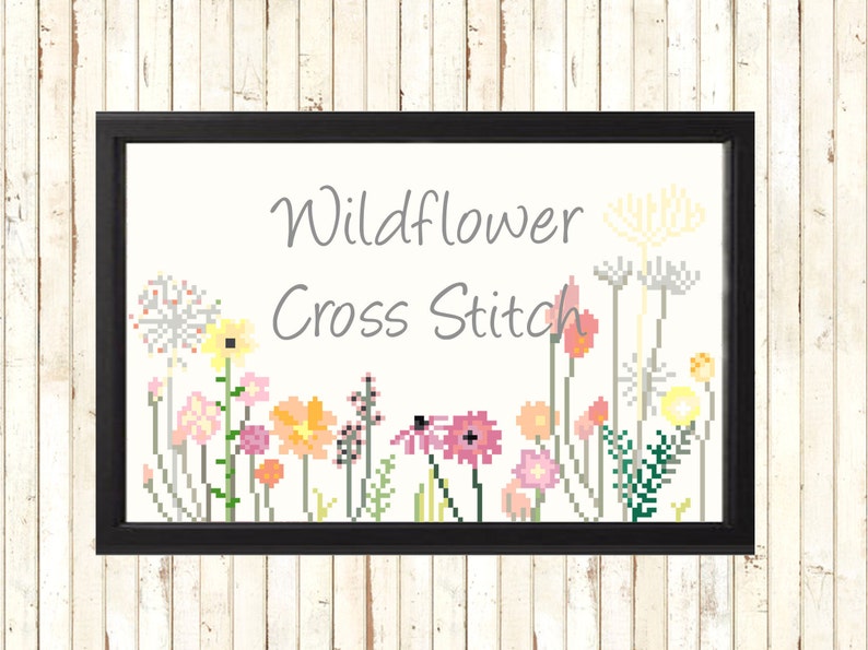 May include: Framed cross-stitch art featuring a colorful wildflower design. The artwork includes various pixelated flowers in shades of pink, yellow, orange, and green, with the words "Wildflower Cross Stitch" in gray text.