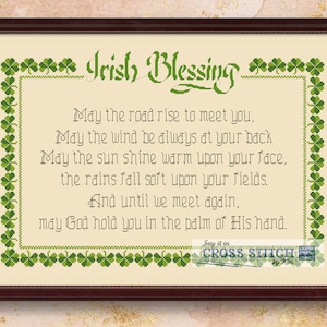 May include: A framed cross-stitch pattern with a green shamrock border and the text "Irish Blessing" in a decorative font. The text reads: "May the road rise to meet you, May the wind be always at your back May the sun shine warm upon your face. the rains fall soft upon your fields. And until we meet again, may God hold you in the palm of His hand."