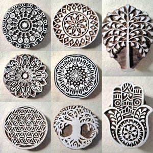 Può includere: Nove blocchi di stampa in legno con disegni intricati. I disegni includono mandala, alberi e una mano di hamsa. I blocchi sono in legno scuro e hanno una finitura naturale.