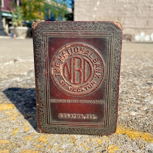 Vintage metal book piggy bank advertising The National Bank of Decatur